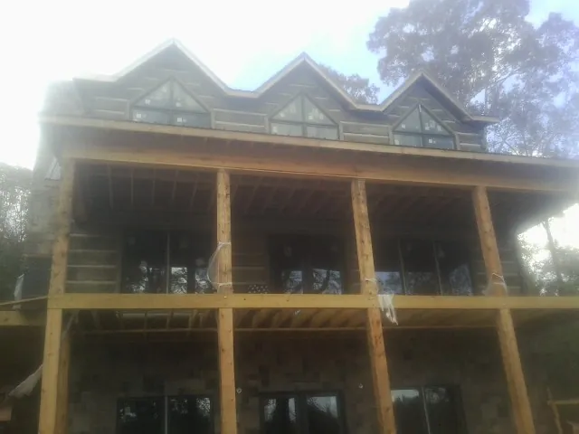 Dormers and porch framing on a large log home under construction — Roof Coating work by our crew in Jeannette