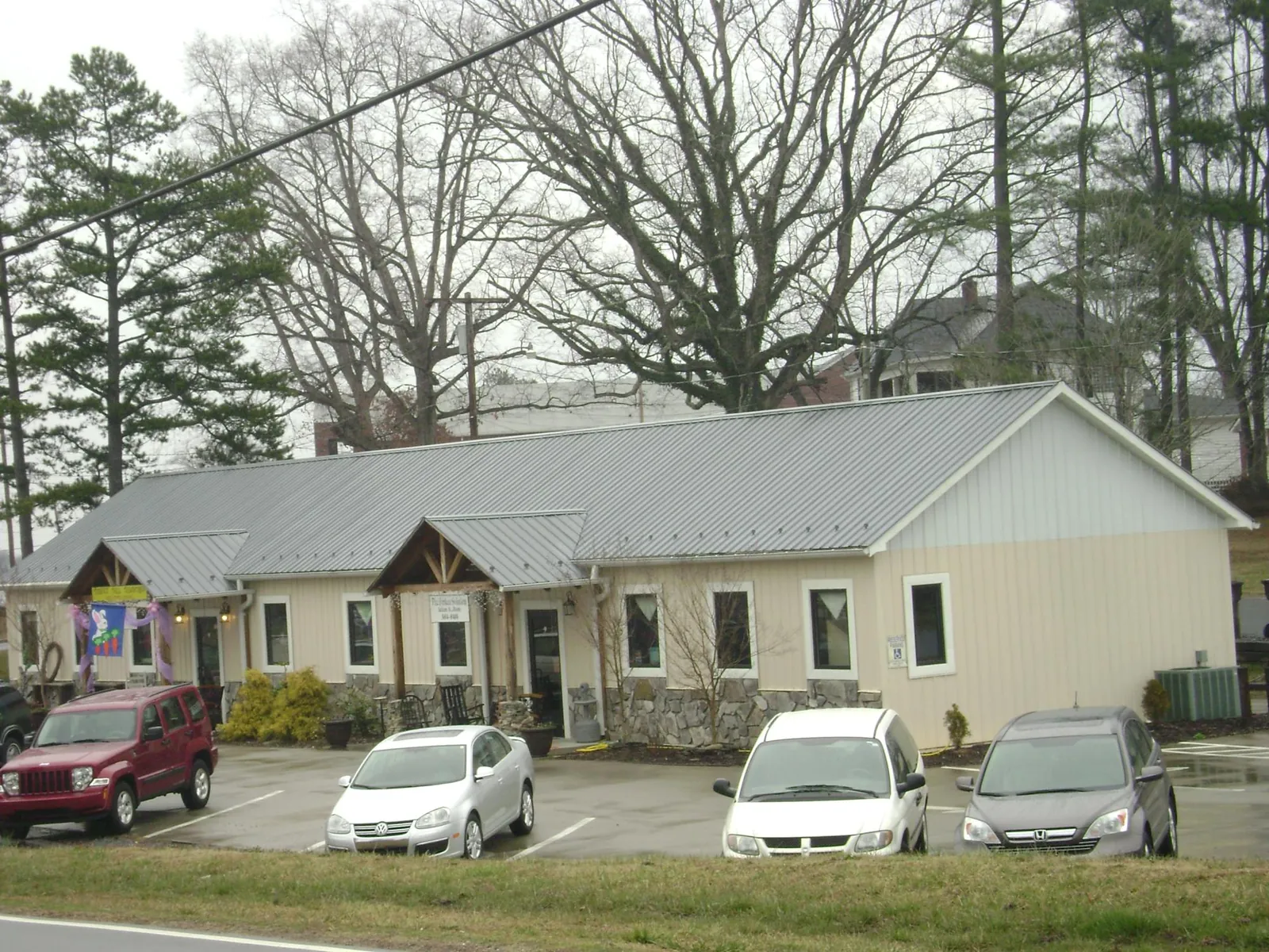 Gray metal roof with timber entry brackets on a small commercial building in Jeannette