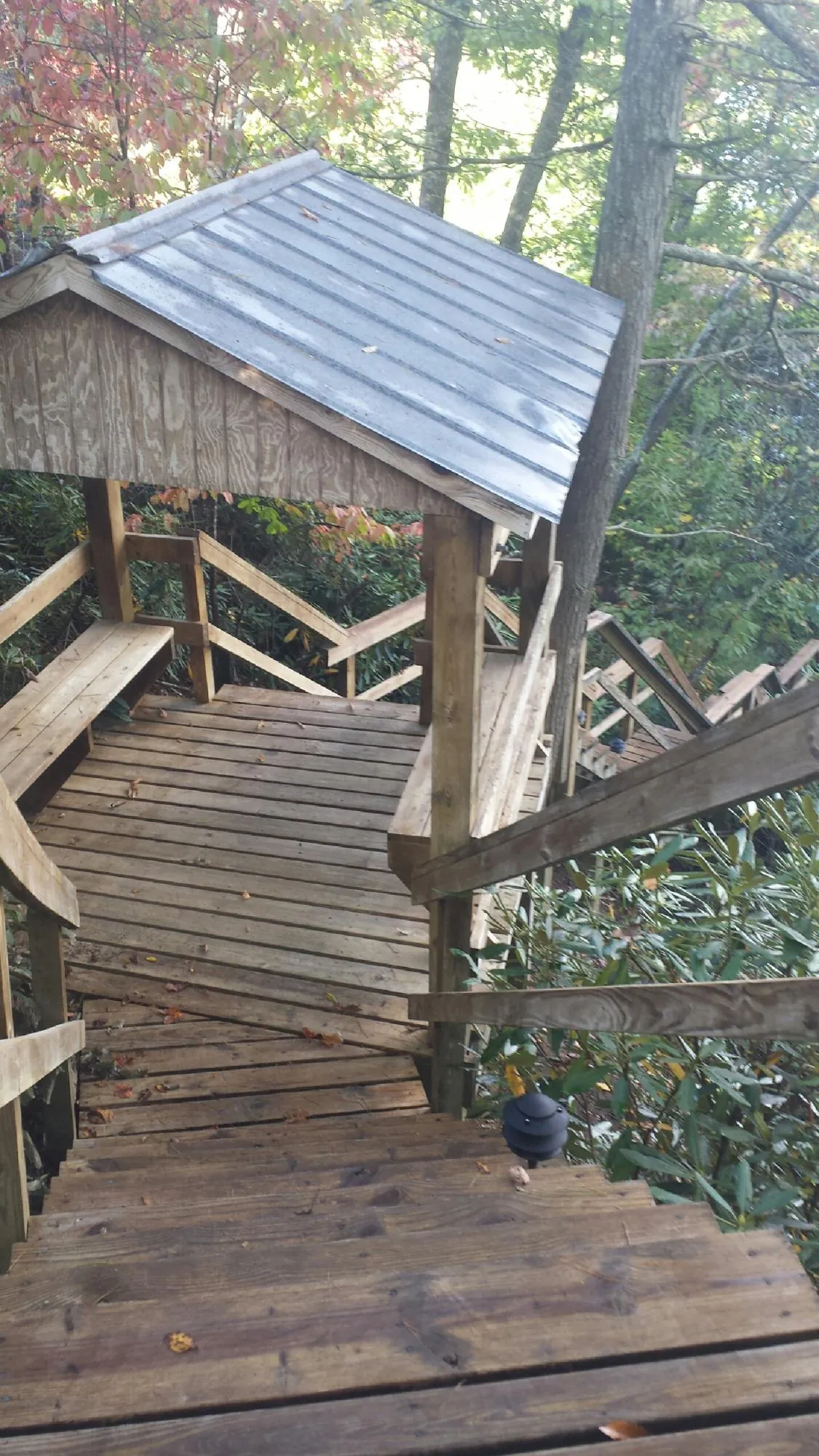 Metal roofed shelter over wooden steps on a wooded walkway — Skylight Repair & Installation work by our crew in Jeannette