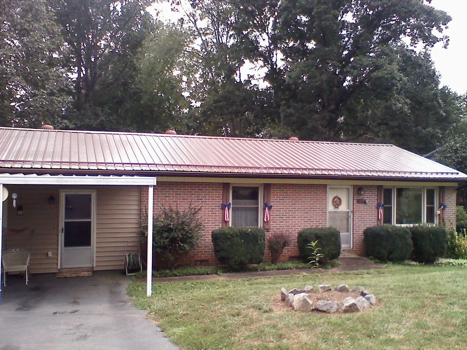 Bronze metal roof and carport on a brick ranch home — Roof Repair work by our crew in Jeannette