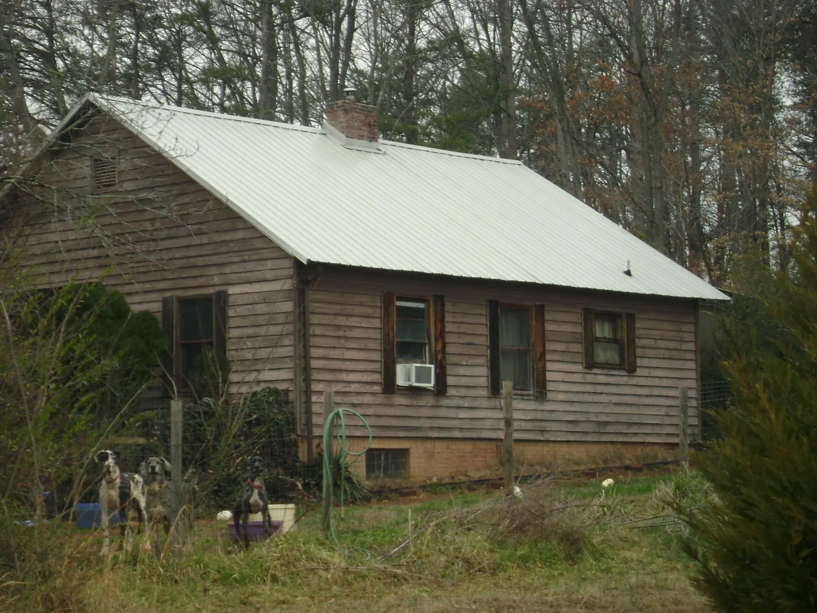 White metal roof on an old wood sided farmhouse, from a Metal Roof Installation job in Jeannette